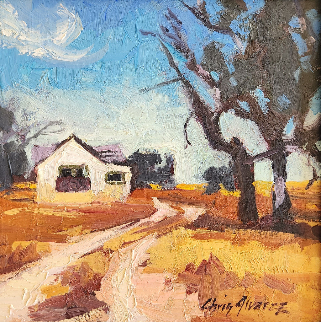 Impressionist painting depicting a road leading up to a house. The road is just two tire tracks while the ground outside the road is a yellow and orange color. The house is a white tan color with a purple roof and green shutters. The trees around the house are bare as if it is fall or winter. The sky above the house are different shades of bright blue. 8"x8" oil by Chris Alvarez